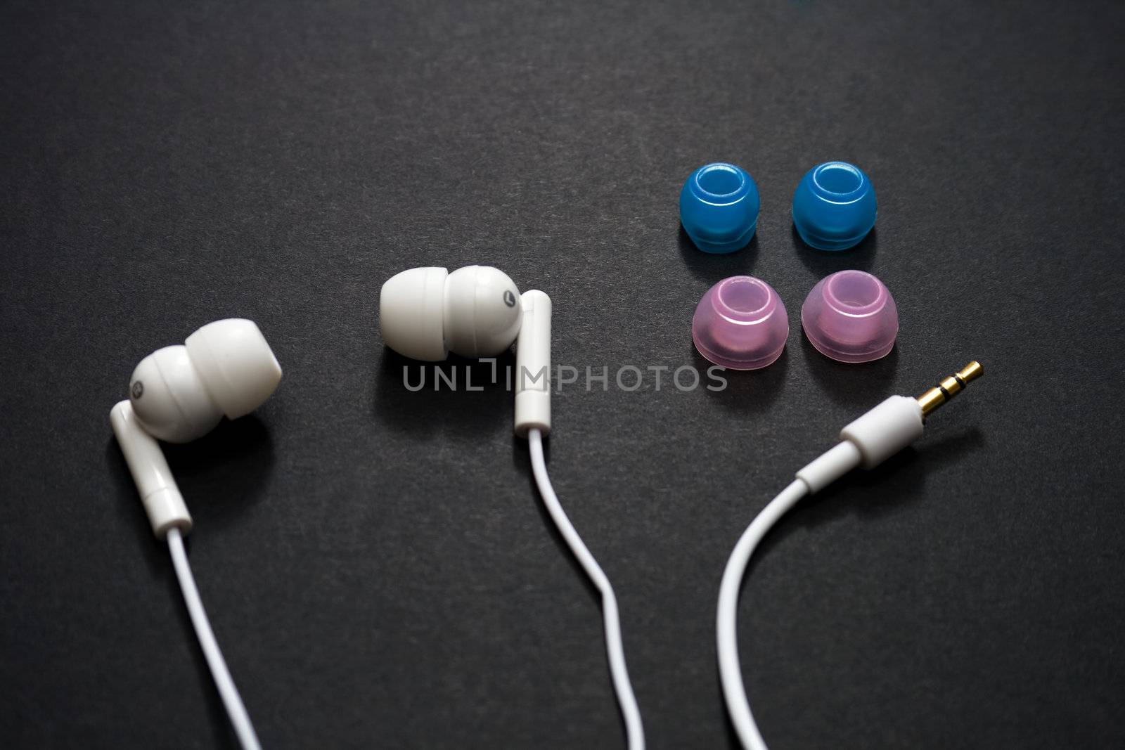 White earbuds and spare parts on a dark background