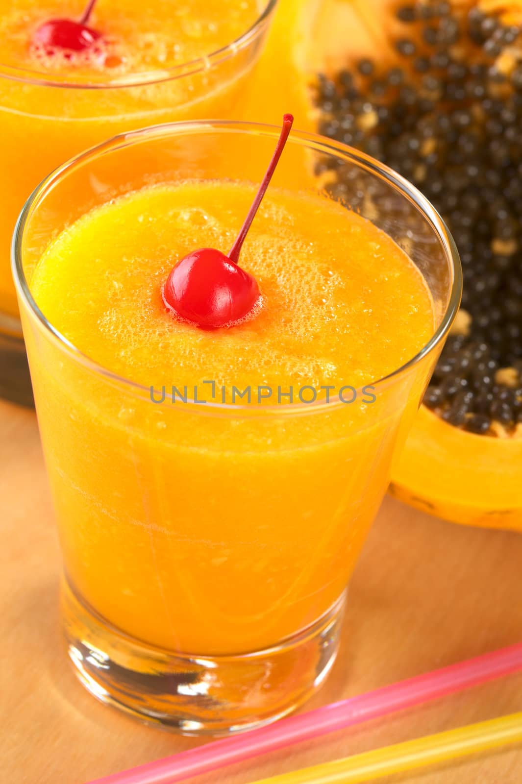 Fresh blended papaya juice garnished with a maraschino cherry (Selective Focus, Focus on the cherry) 