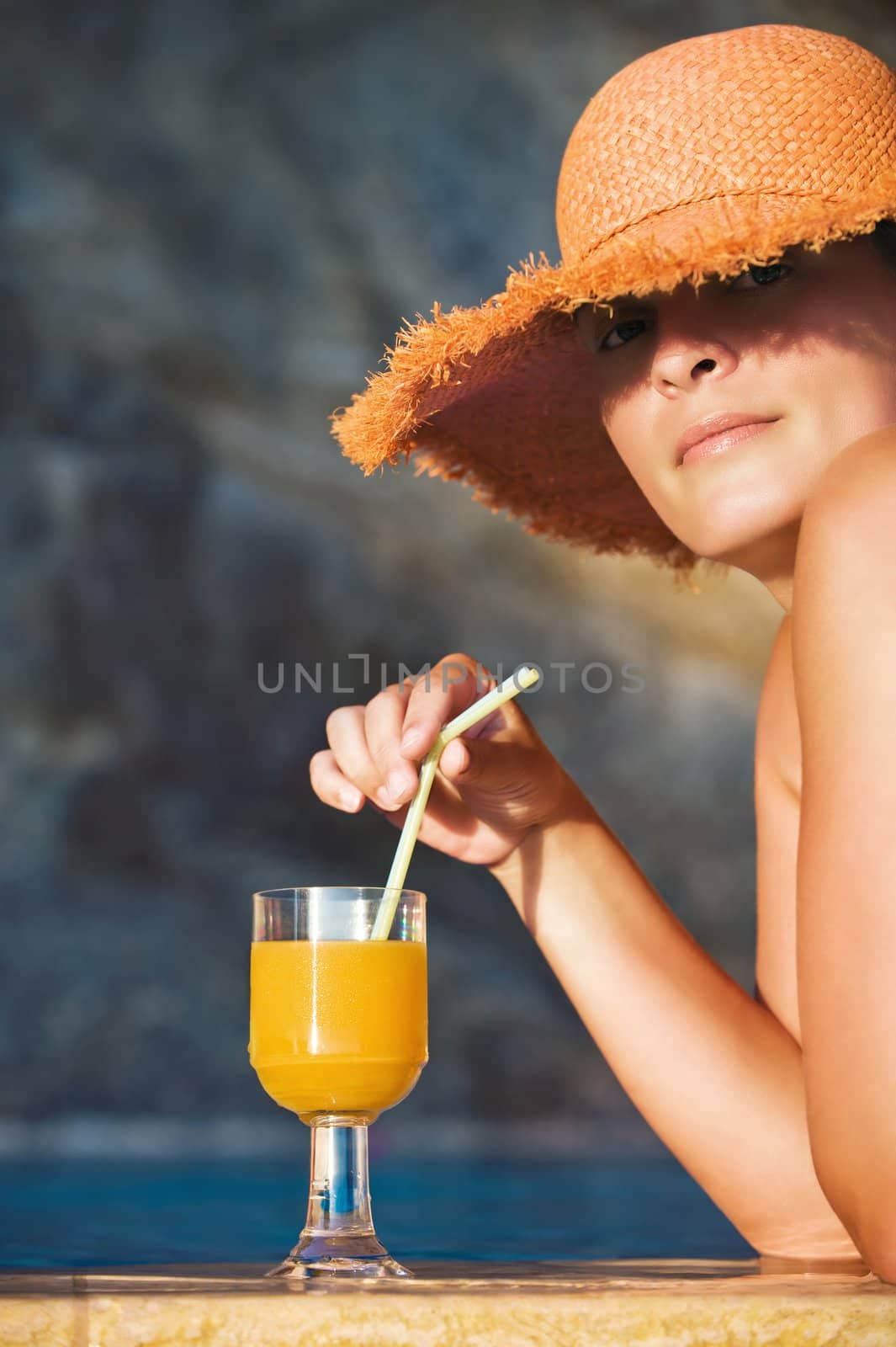 Attractive woman in hat with glass of orange juice by akarelias