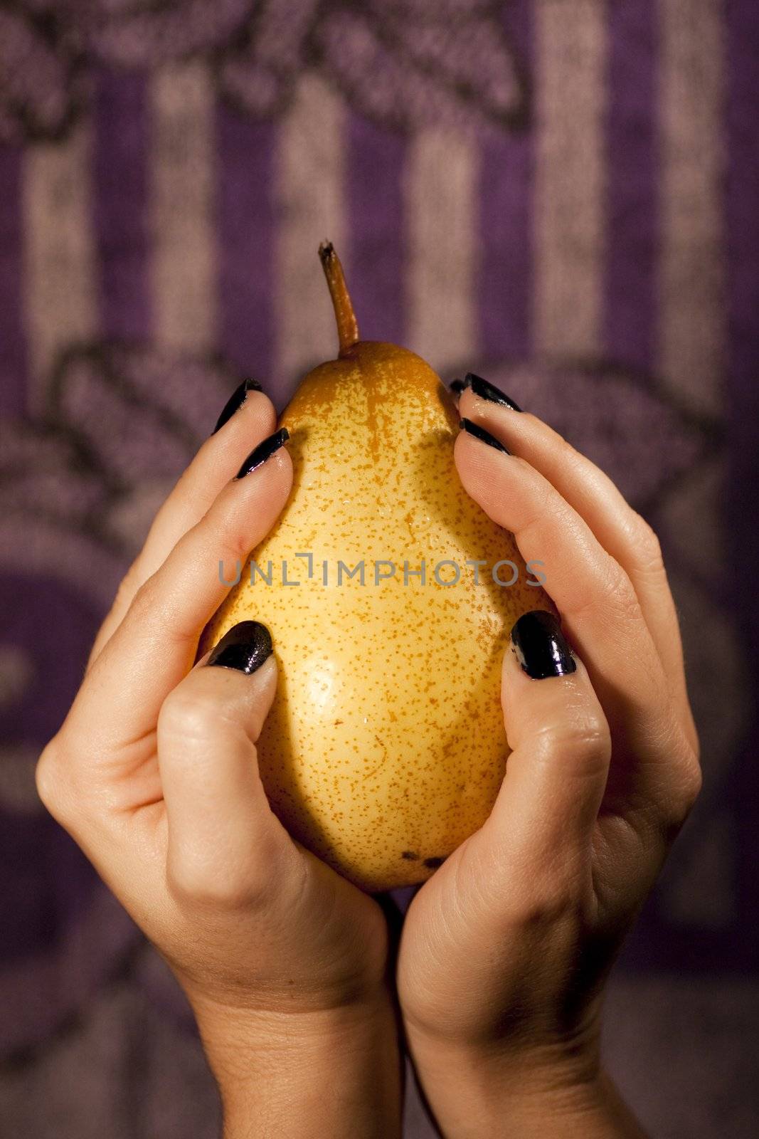 View of a woman hands holding a pear.