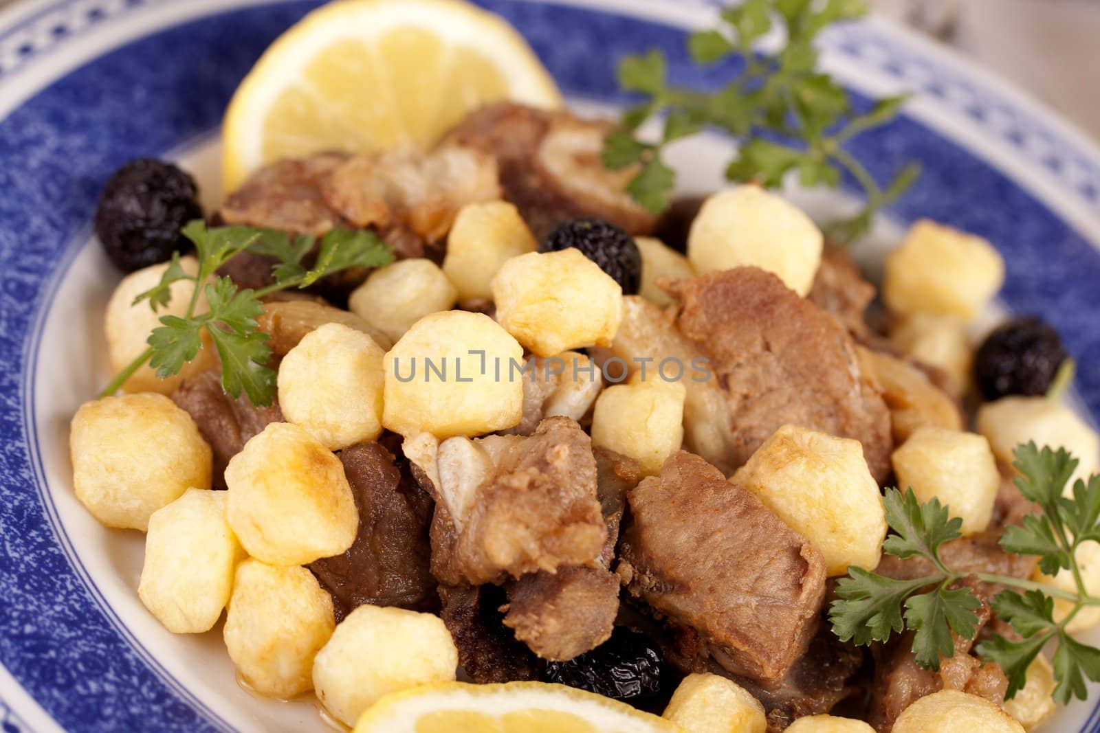 Close up view of a Portuguese meal of cooked meat with potatoes.