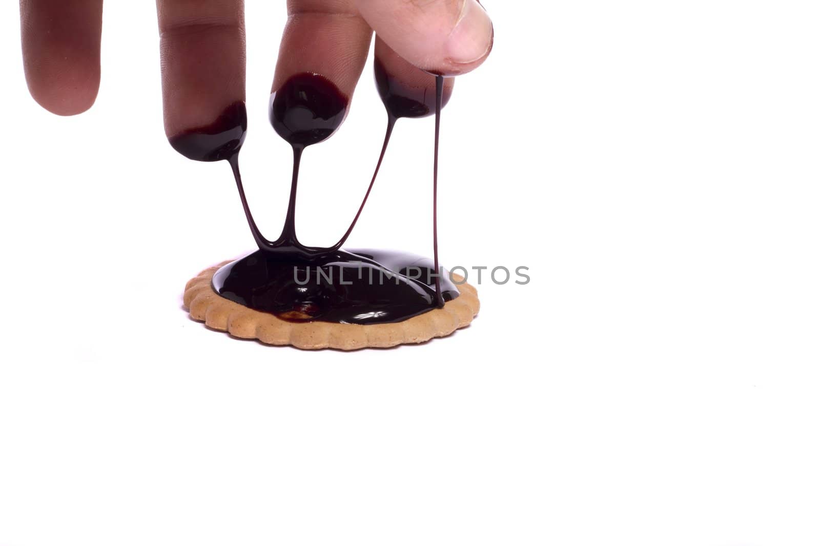 View of a round biscuit isolated on a white background with a drip of dark chocolate.