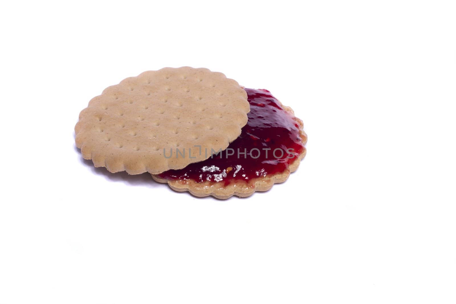 View of a round biscuit isolated on a white background with berry jam.