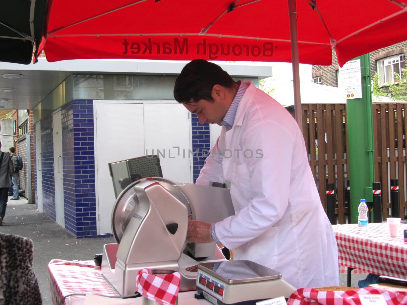 Unidentified man slicing meat a ham stall at Borough Market on A by green308