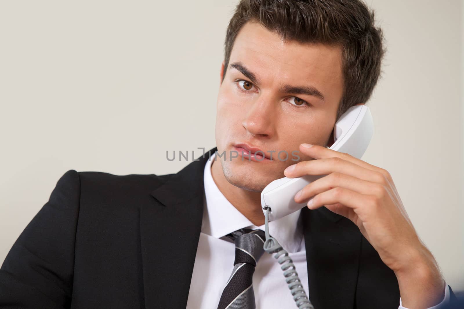 Portrait of businessman conversing on landline phone by krzysiek_z_poczty