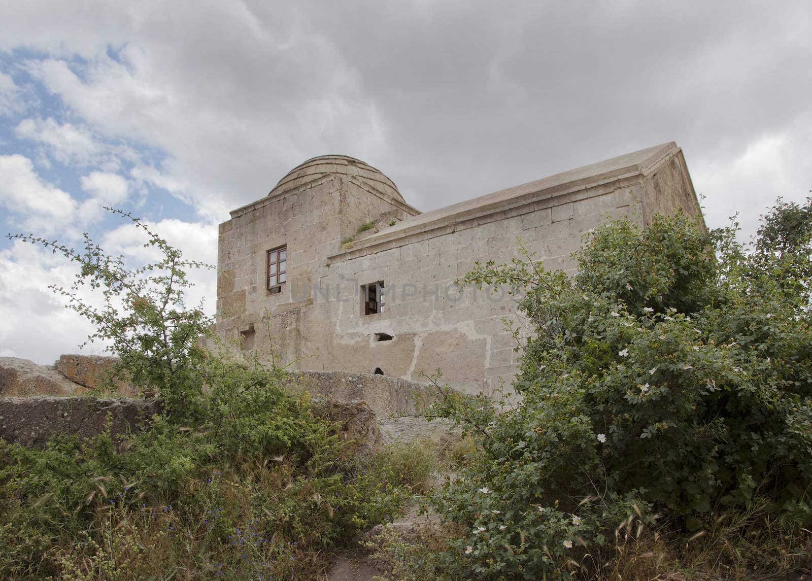landscape and relics of disused church with dome Cappadocia Turkey, overgrown gardens, blue sky, clouds, crop area, copy area and horizontal