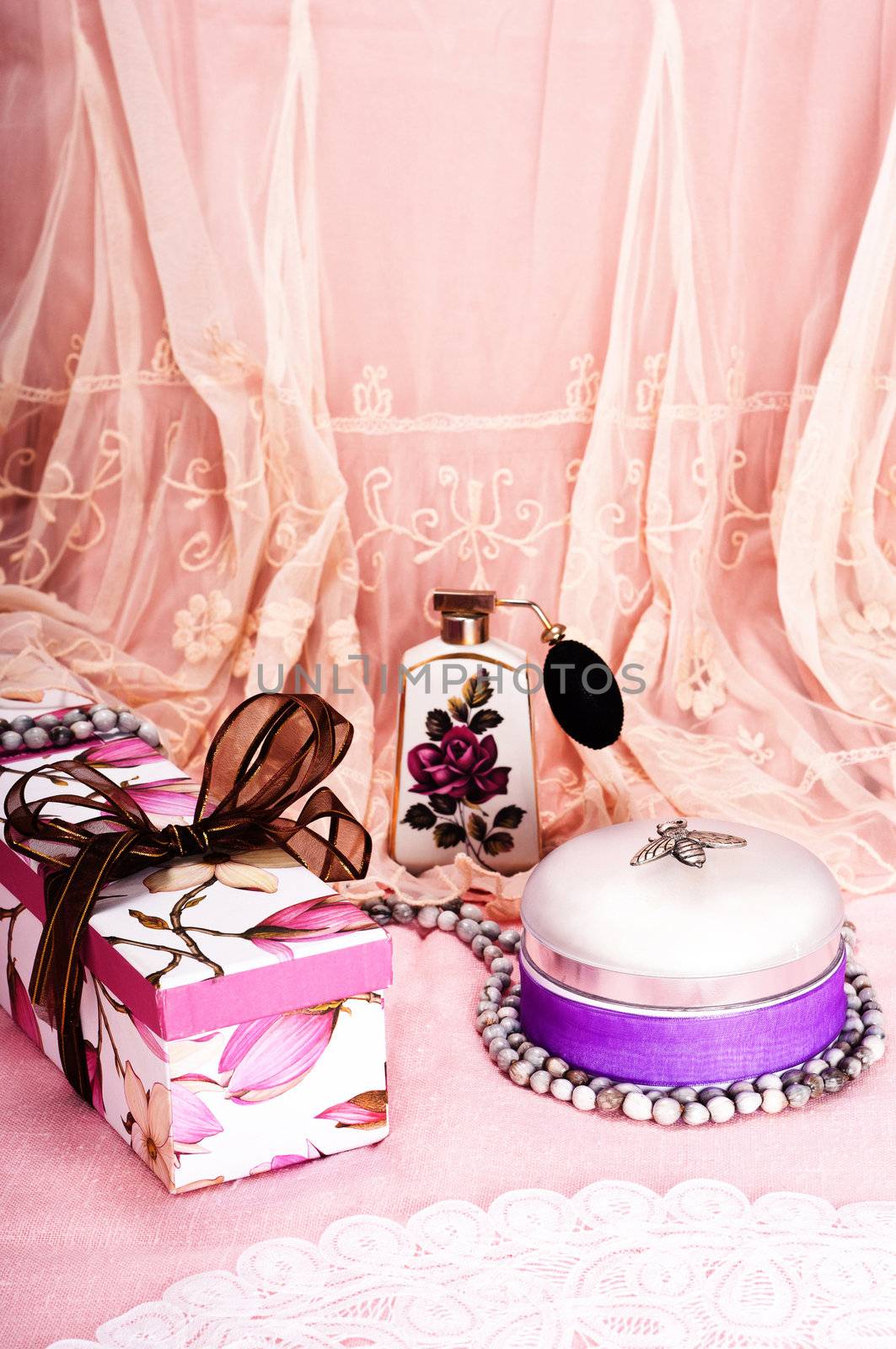 Feminine birthday or holiday celebration with gift box, perfume and talcum powder