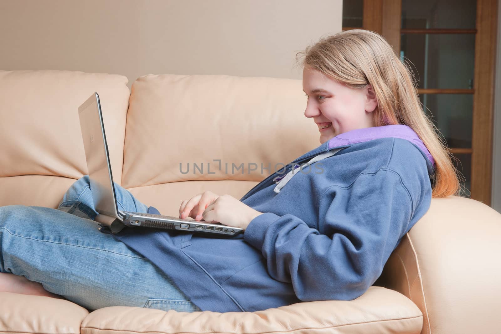 teenager using laptop on sofa by clearviewstock
