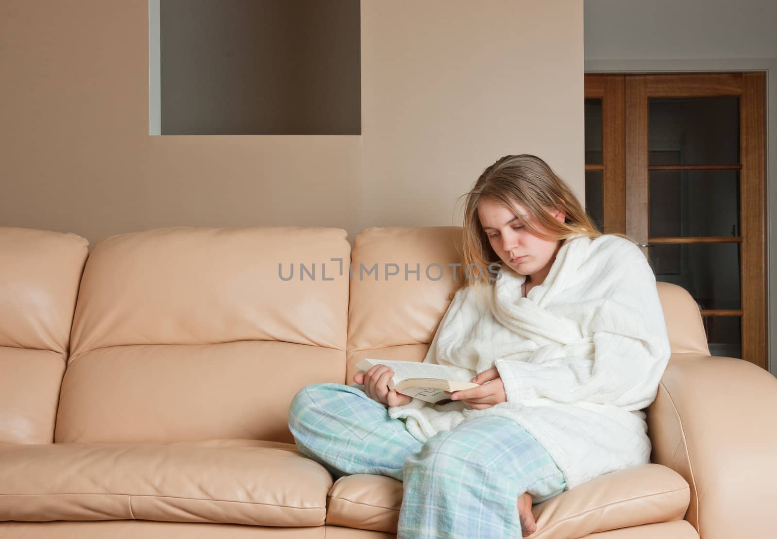 young woman reading a book on sofa