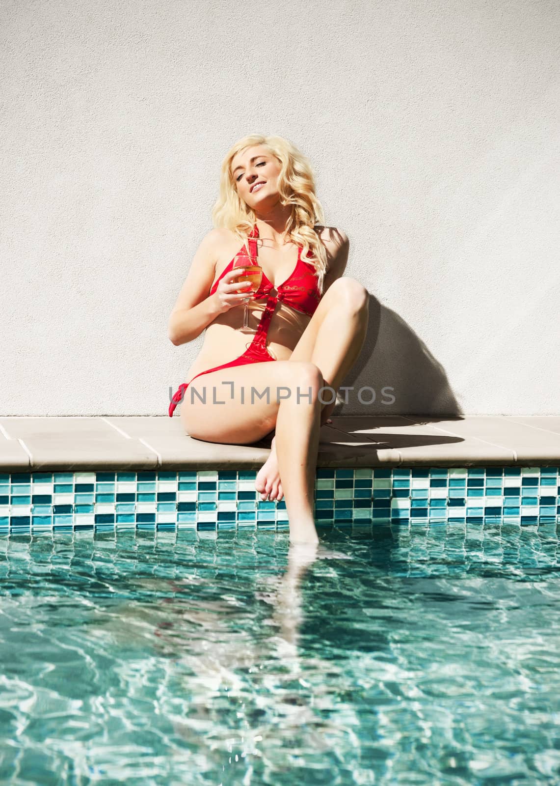beautiful sexy woman sitting by the swimming pool