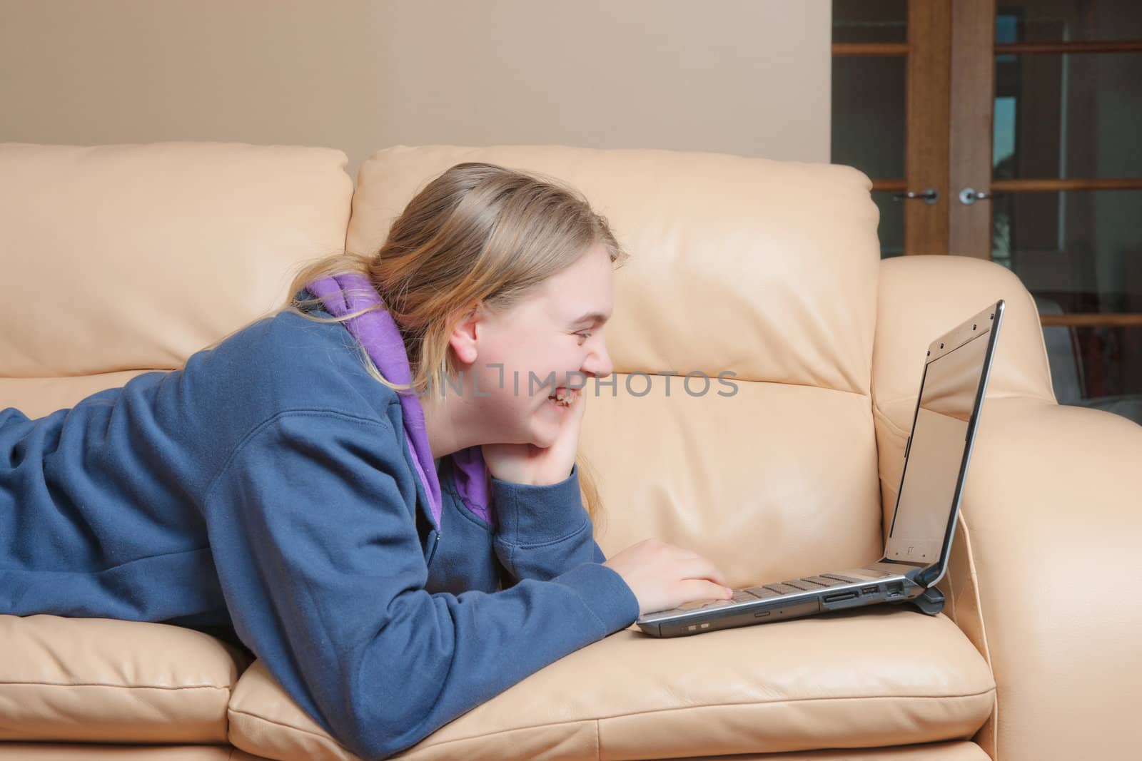 young teenage woman using a laptop on the sofa