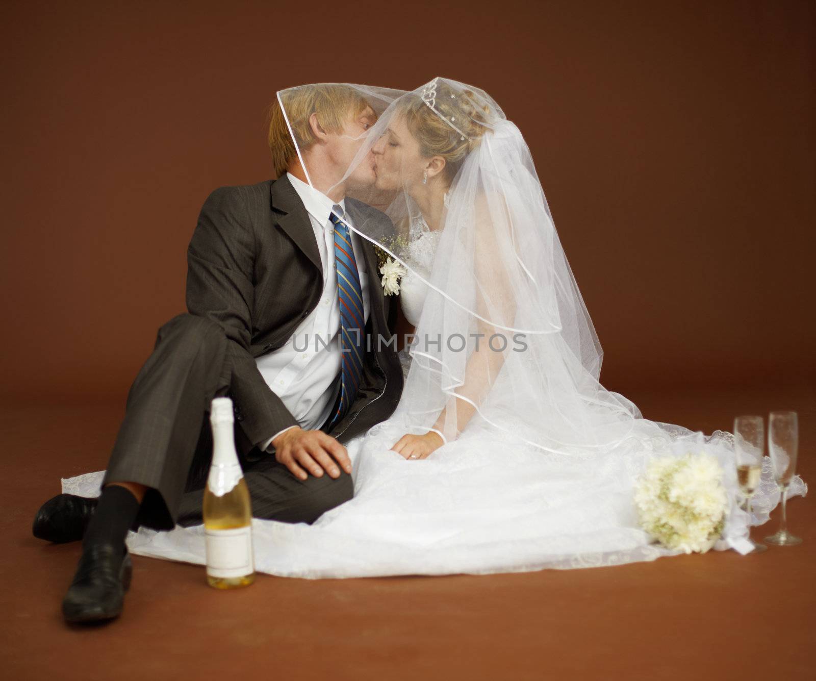 The bride and groom kissing and drinking champagne wine