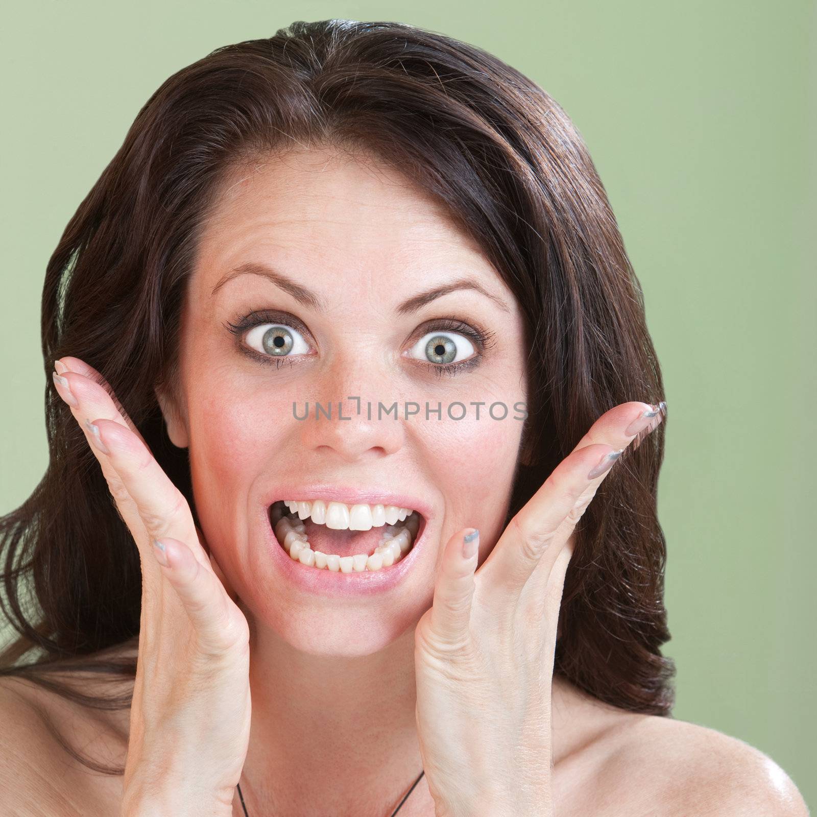 Excited Caucasian woman with raised eyebrows over green background