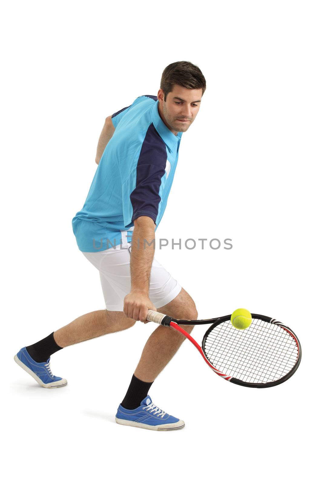 Photo of an attractive male tennis player hitting the tennis ball.