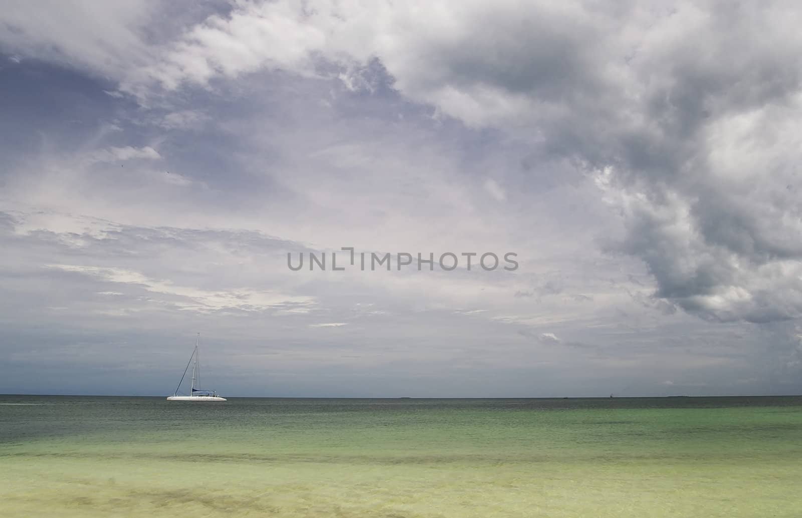 Sailing boatoutside the coast of Cuba, with the sails down