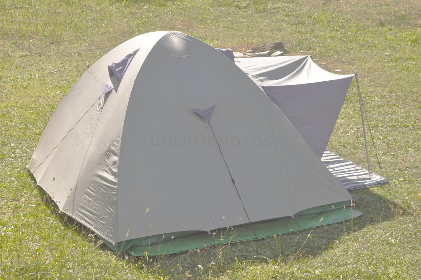 A fabric camping tent shelter in a field