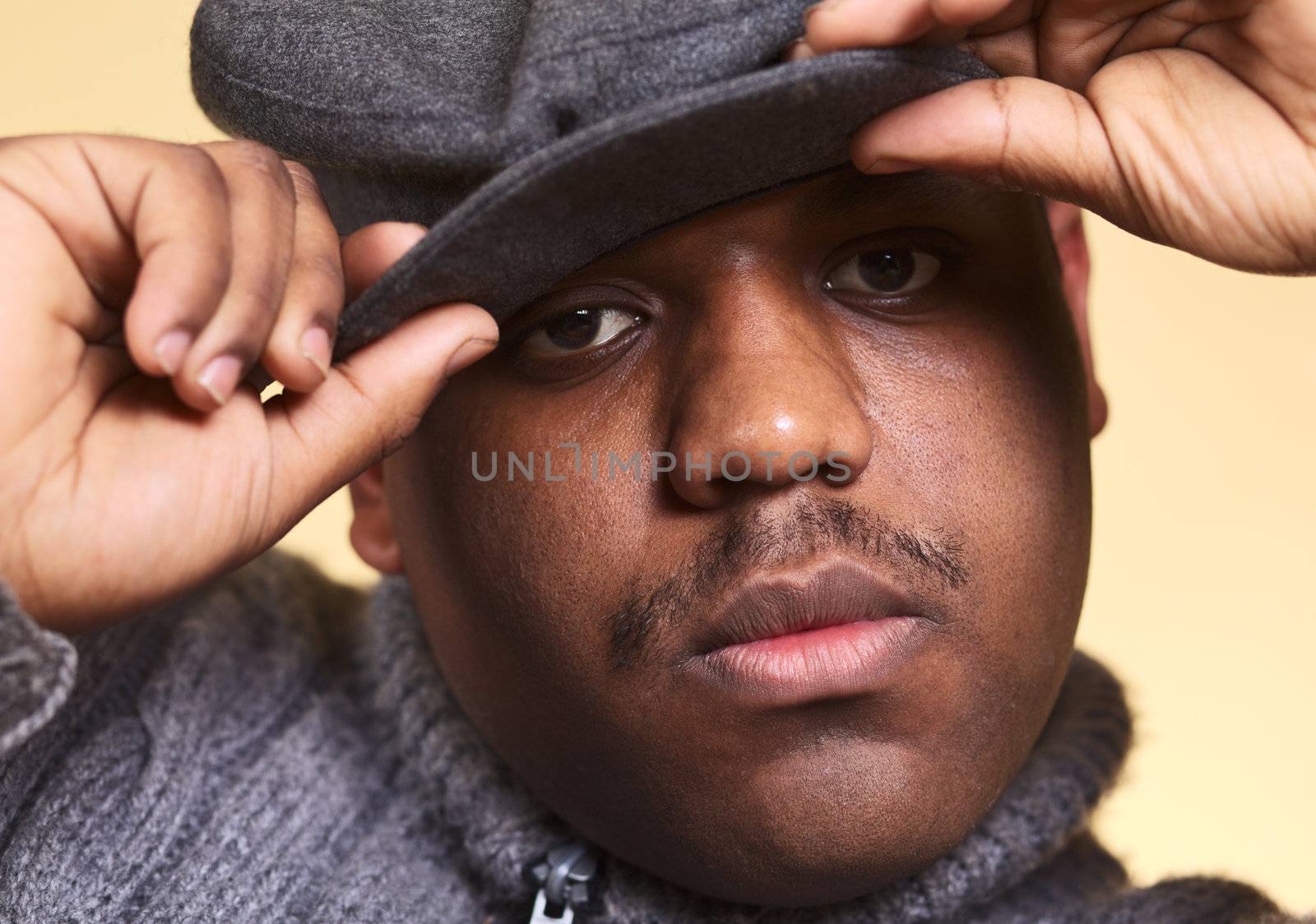 Portrait of a serious young man of African descent with a cap (Selective Focus, Focus on the right eye)