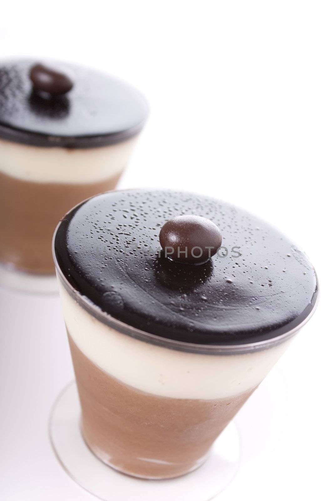 Chocolate and cream dessert in a plastic cup,  topped with dark chocolate and a chocolate covered coffee bean.