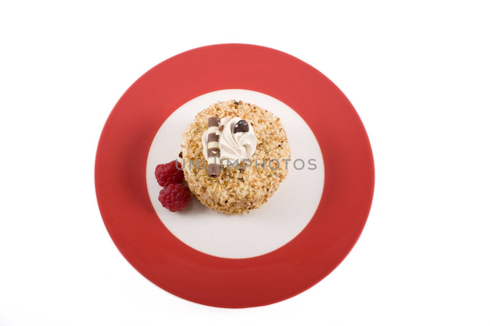 Hazelnut cake on red plate with raspberries.  Shot from directly above and isolated on white background.