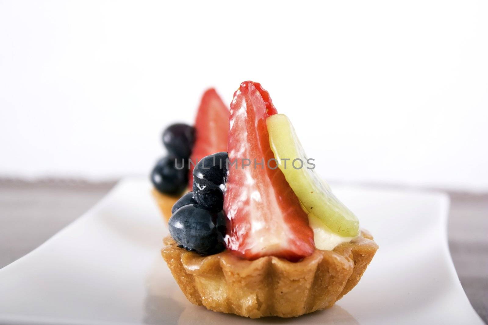 Mini pie pastries with fresh strawberry, blueberry and kiwi fruit.