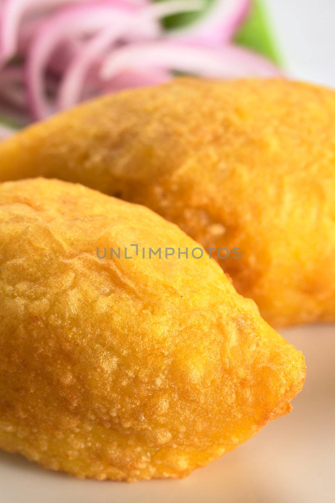 Peruvian dish called Papa Rellena (Stuffed Potato) made of mashed potatoes and filled with meat (Selective Focus, Focus on right front part of the first papa rellena)