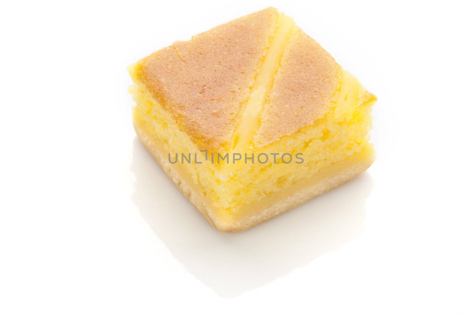 Square slice of yellow cake isolated on white.