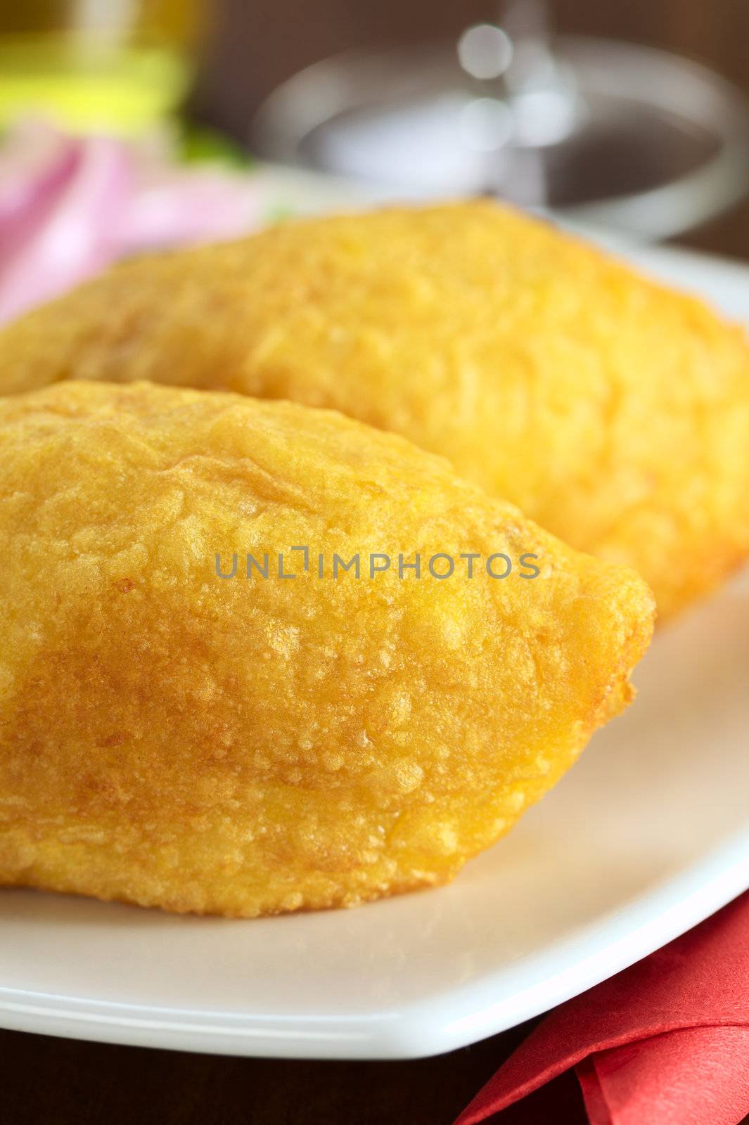 Peruvian dish called Papa Rellena (Stuffed Potato) made of mashed potatoes and filled with meat (Selective Focus, Focus on right front upper part of the first papa rellena)