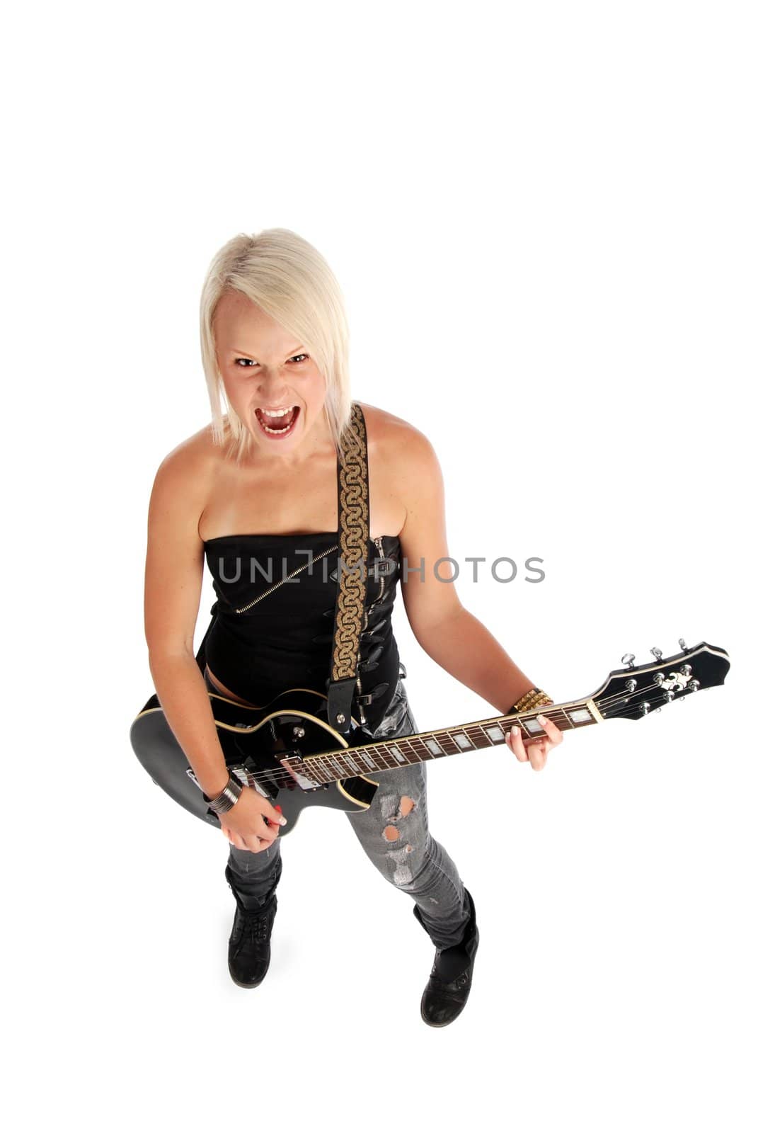 A blond woman screaming while playing guitar.