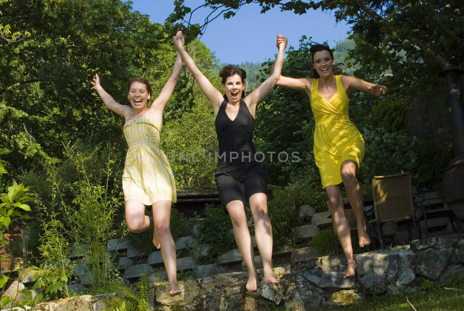 Three girls jumping at the beach, enjoying summertime.