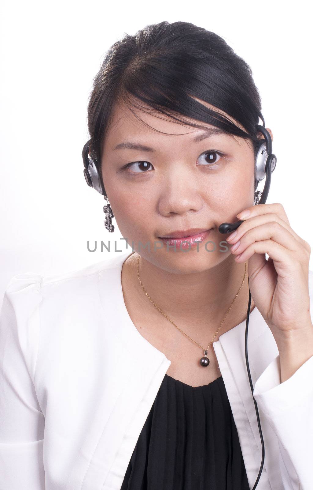 Young asian receptionist talking on hands free headset to customer isolated