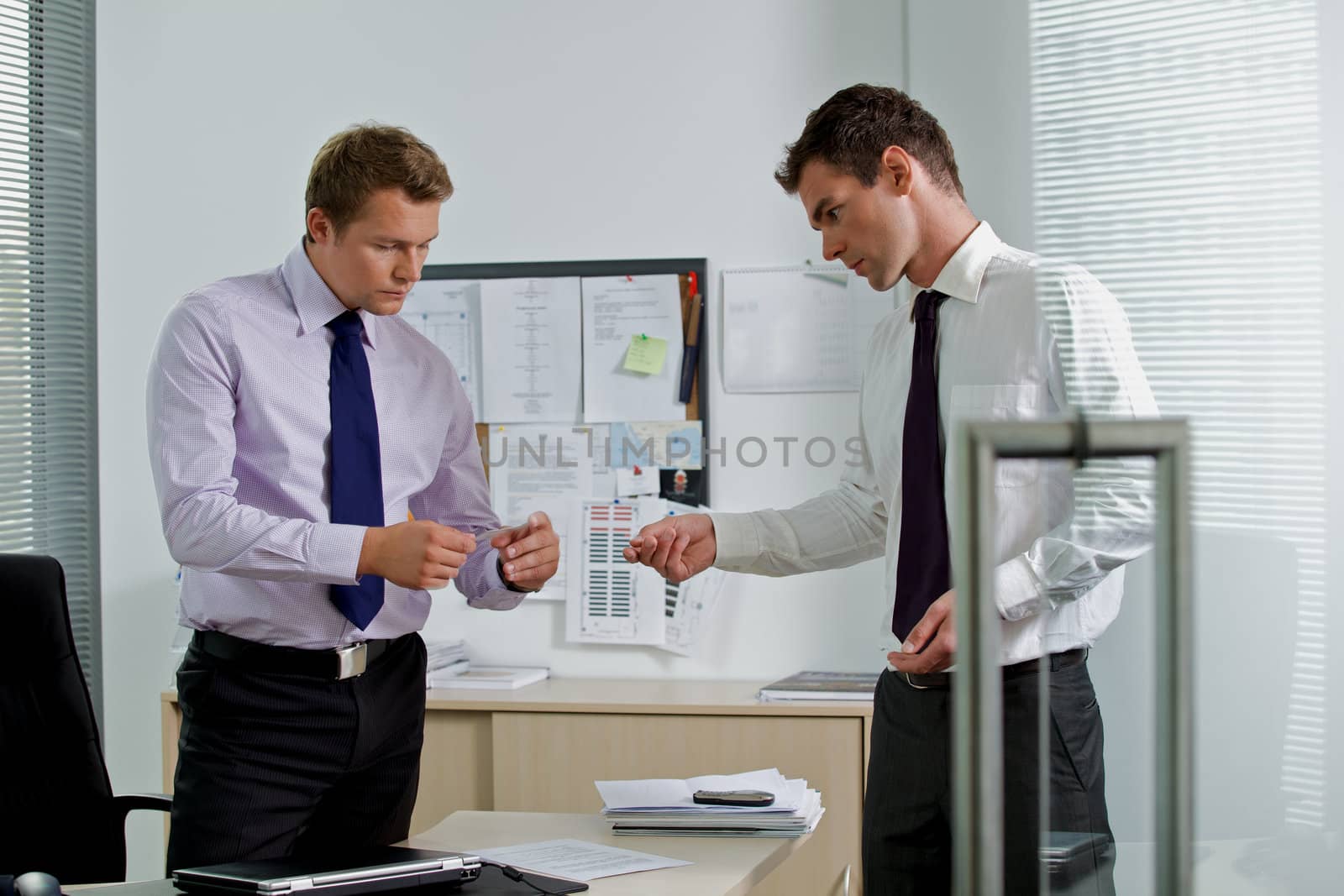 Businessman giving visiting card to colleague