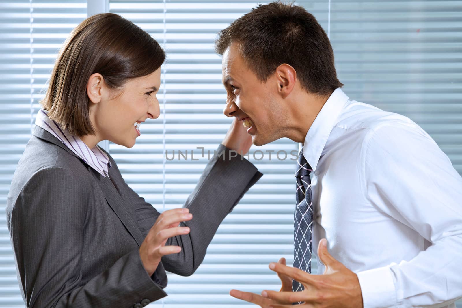 Smiling businessman and woman in office, looking at each other