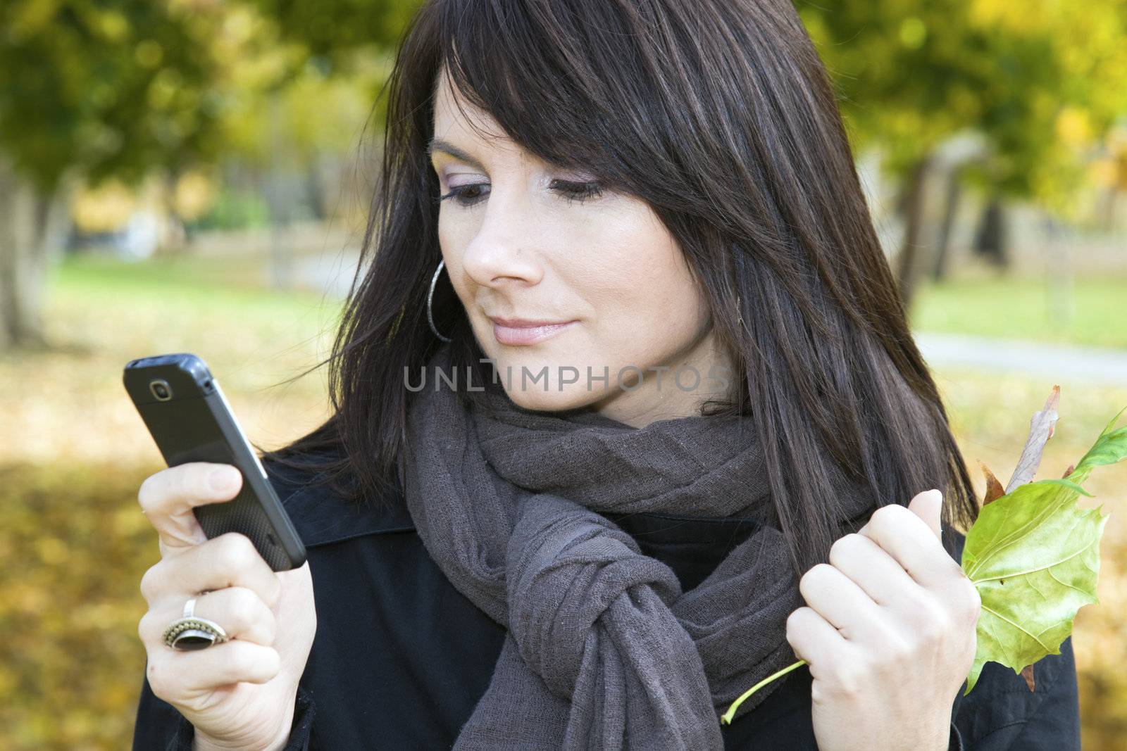 Girl reading text message in colorful park.