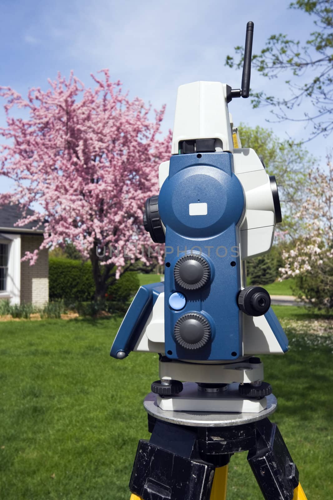 Theodolite and spring colors on trees.
