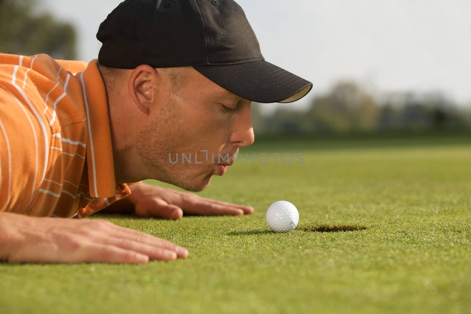 Close-up of man blowing on golf ball