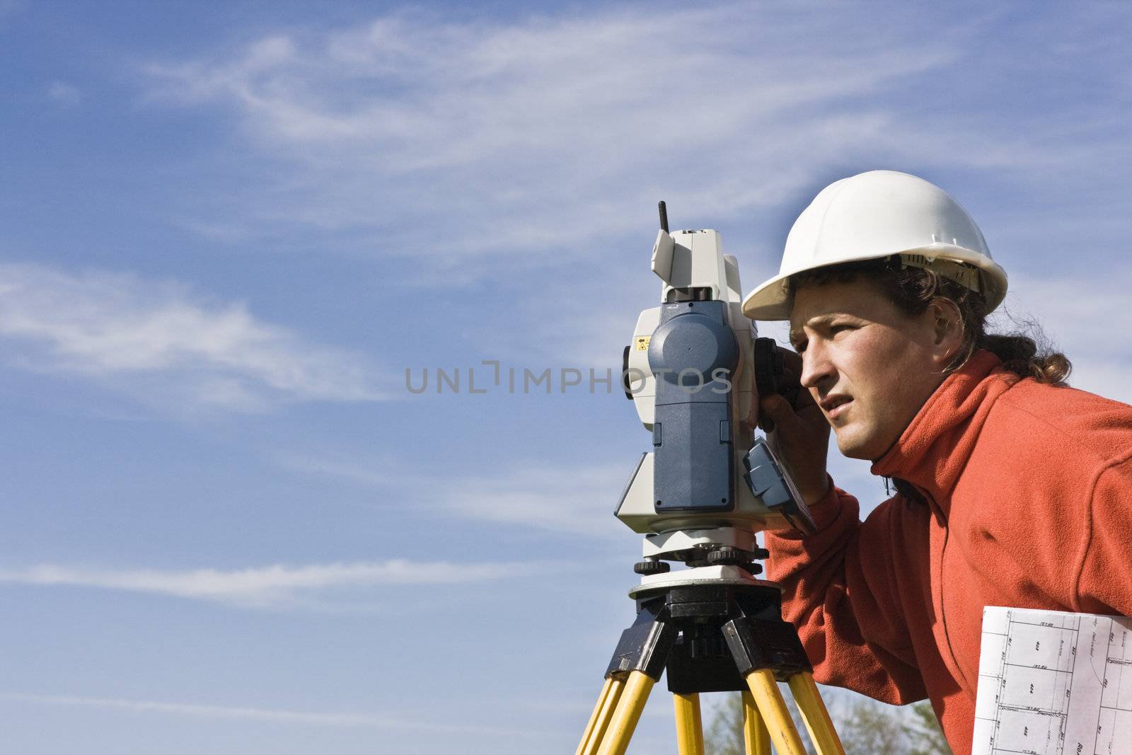 Land Surveying under cloudy sky.