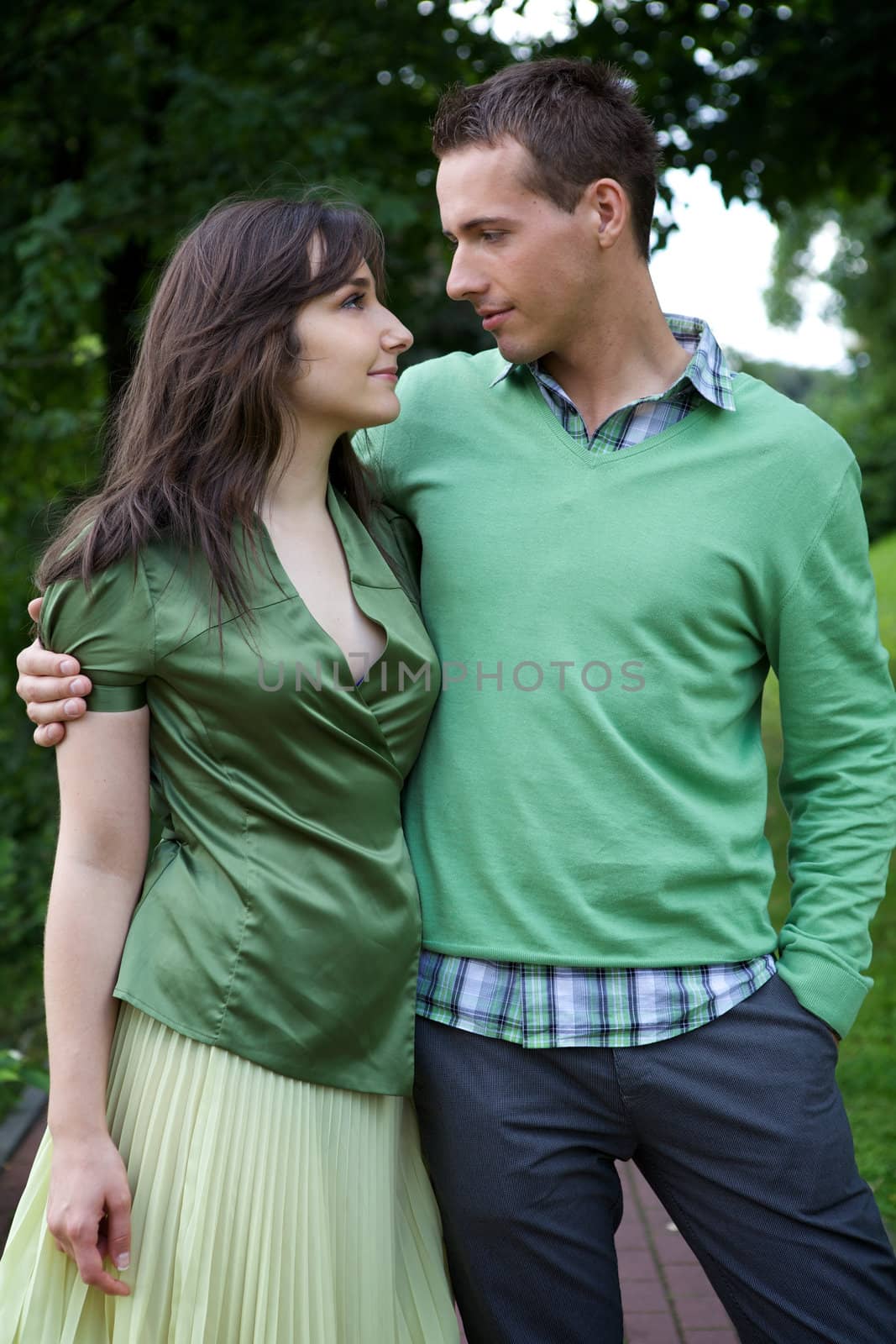 Young couple with arm around and looking at each other