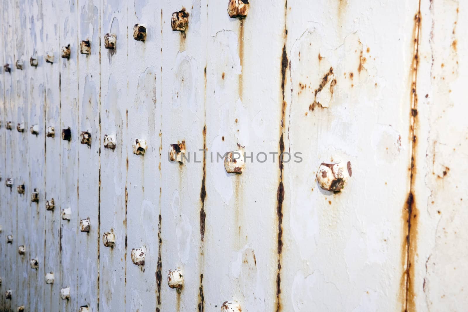 Rusty metal wall with bolts background.