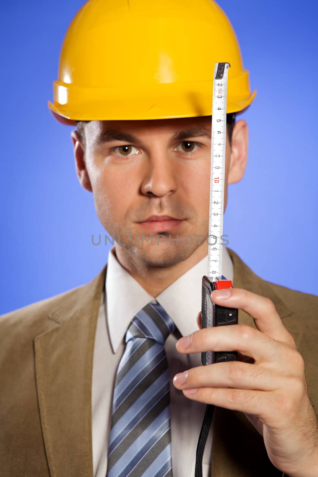 Portrait of businessman in hardhat holding tape measure