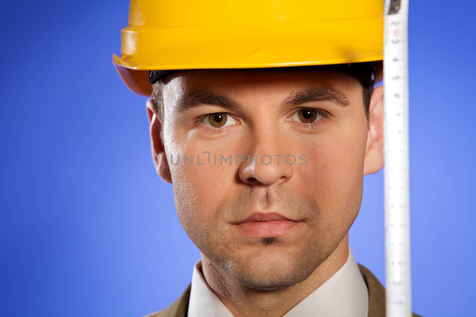 Portrait of businessman in hardhat holding tape measure