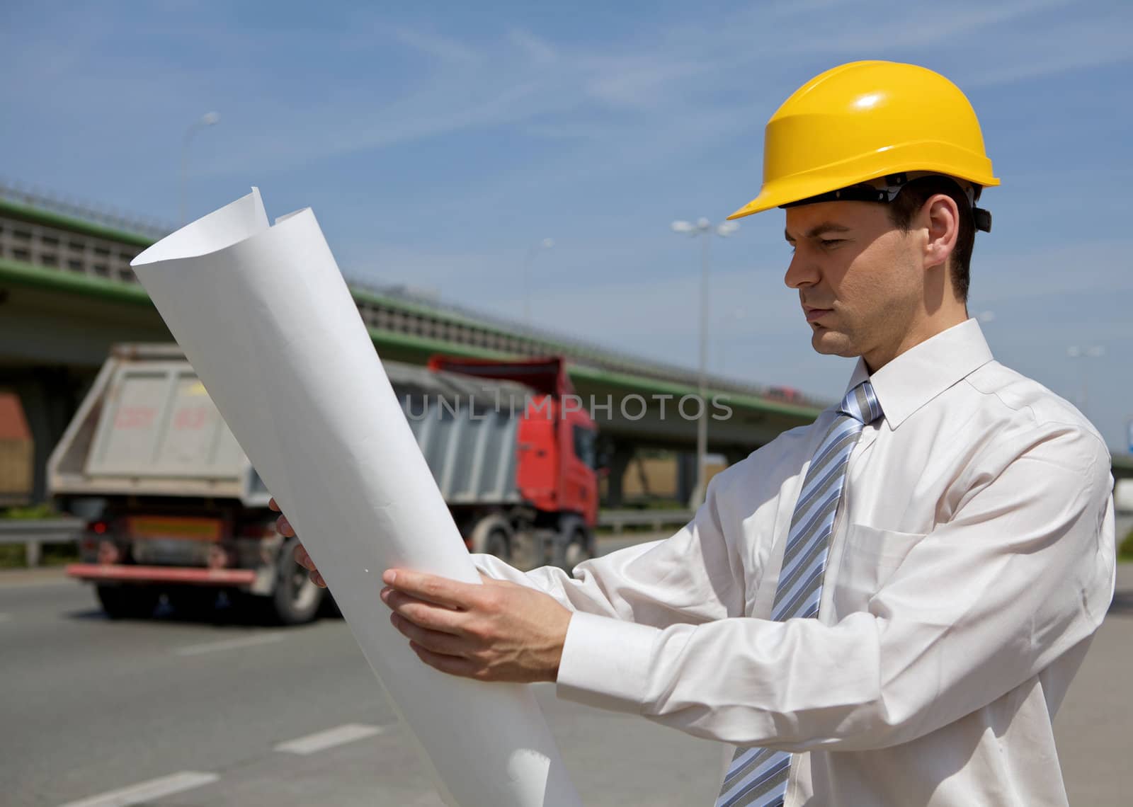 Architect looking at blueprint on construction site