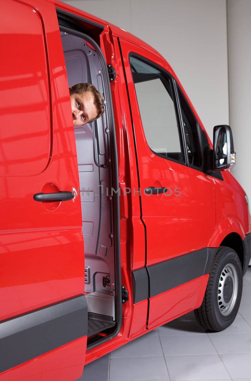 Young man peeking through van door
