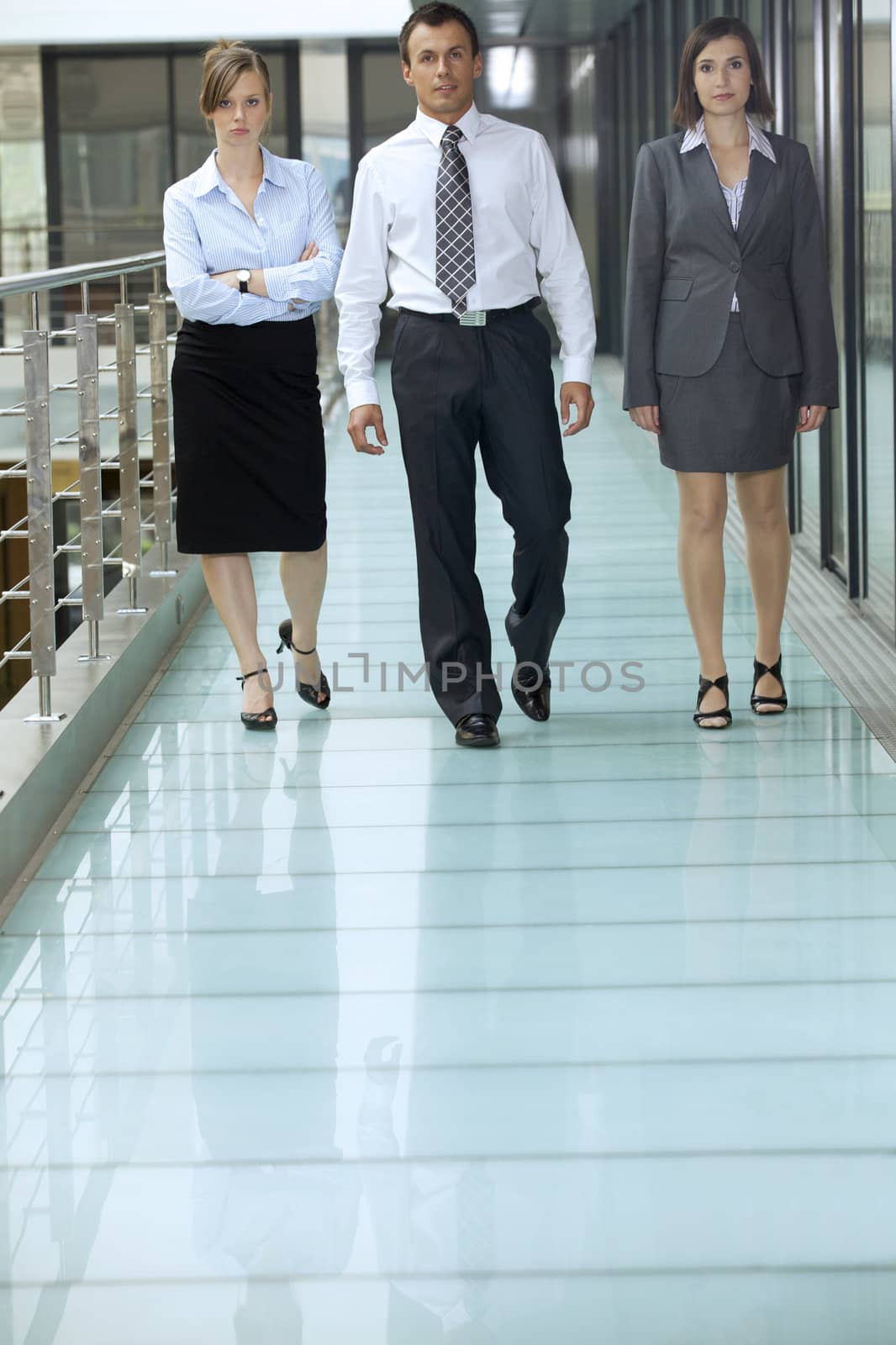 Portrait of business people walking on corridor at office