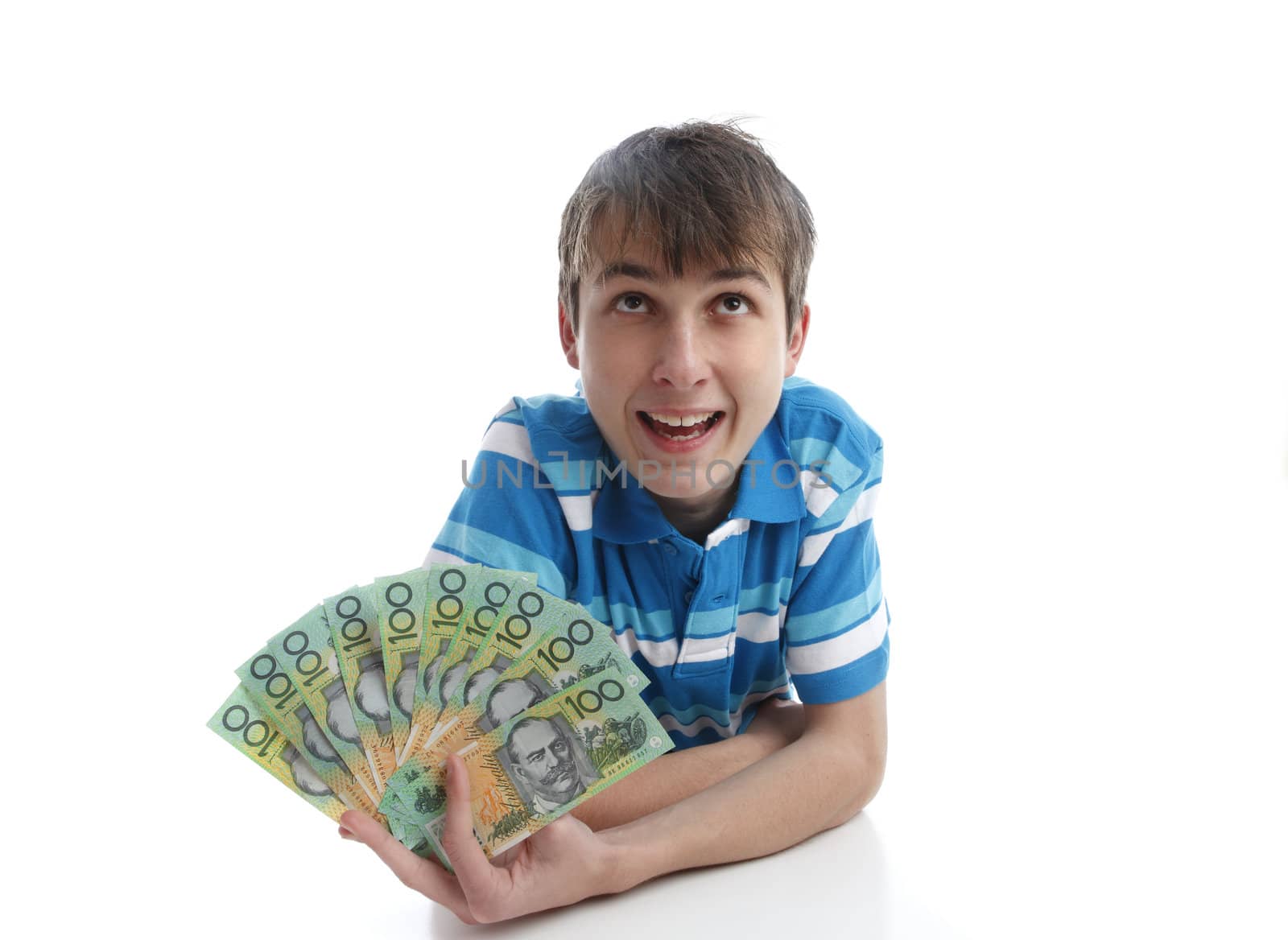 A teen boy holding a fan of money banknotes cash.  eg competition, win, finance, savings, earning, etc