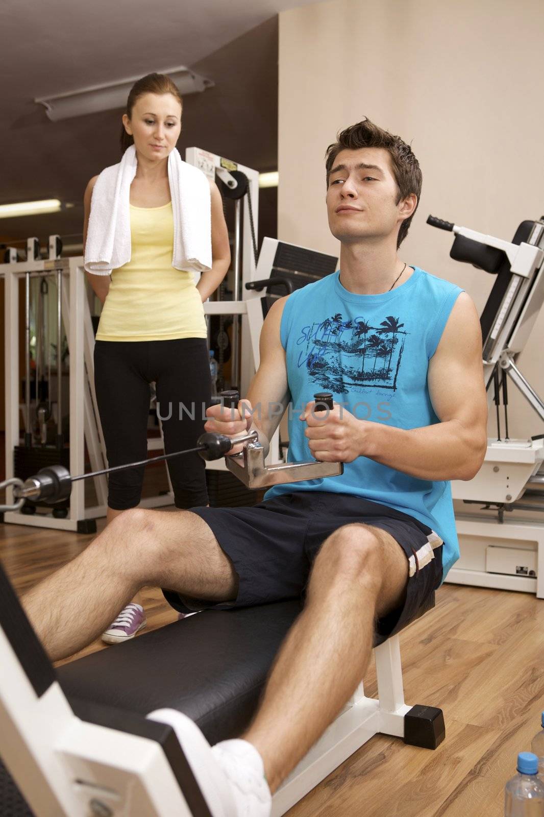 A young man exercising with a personal trainer