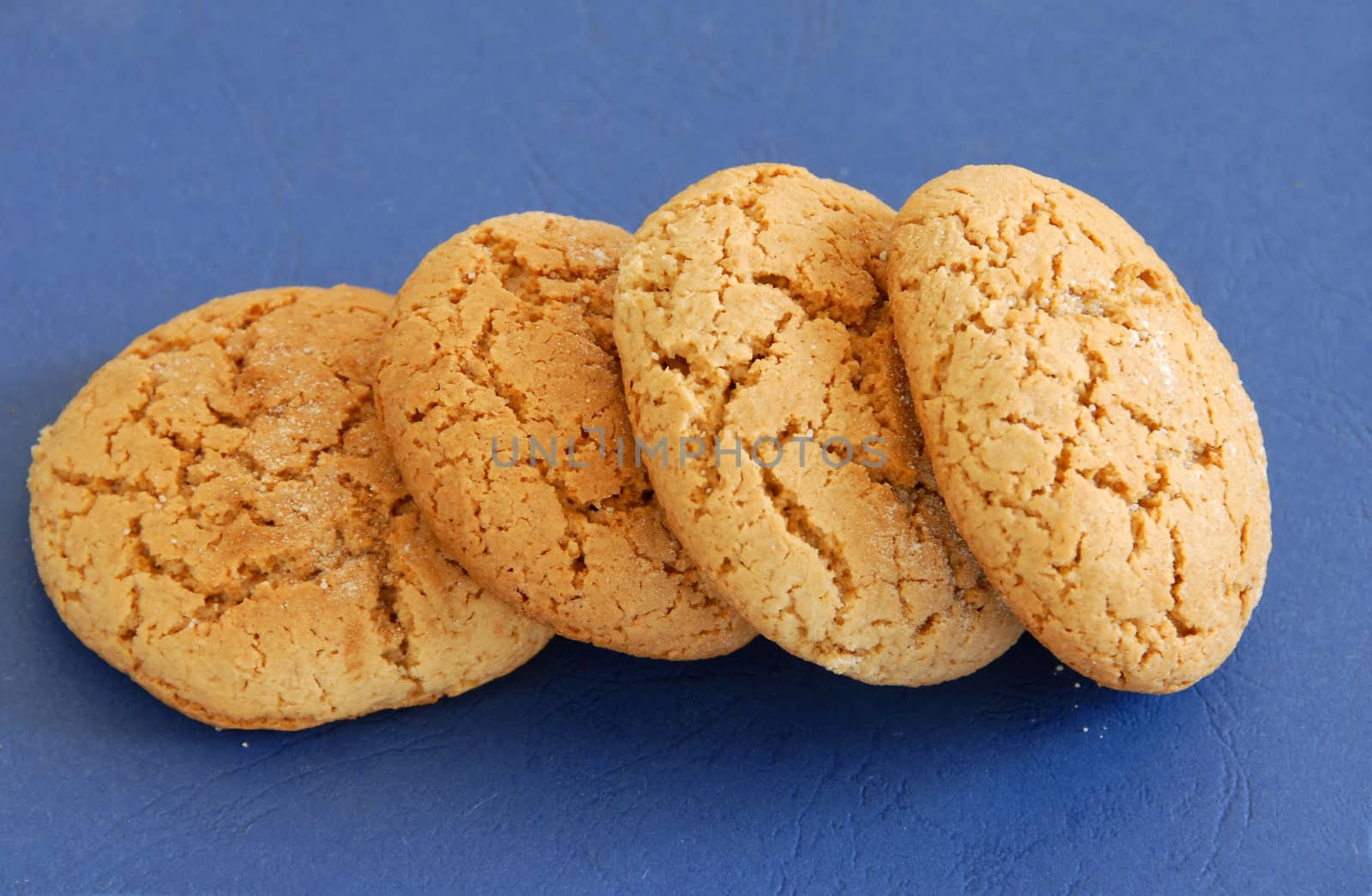 four fresh appetizing oatmeal cookies over blue background