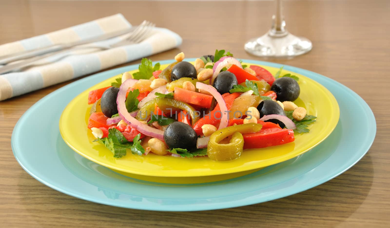 Salad of roasted peppers with tomato, peanuts and olives, onions and greens 