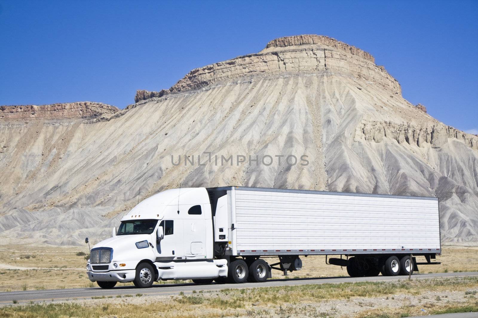 White semi truck driving in Colorado