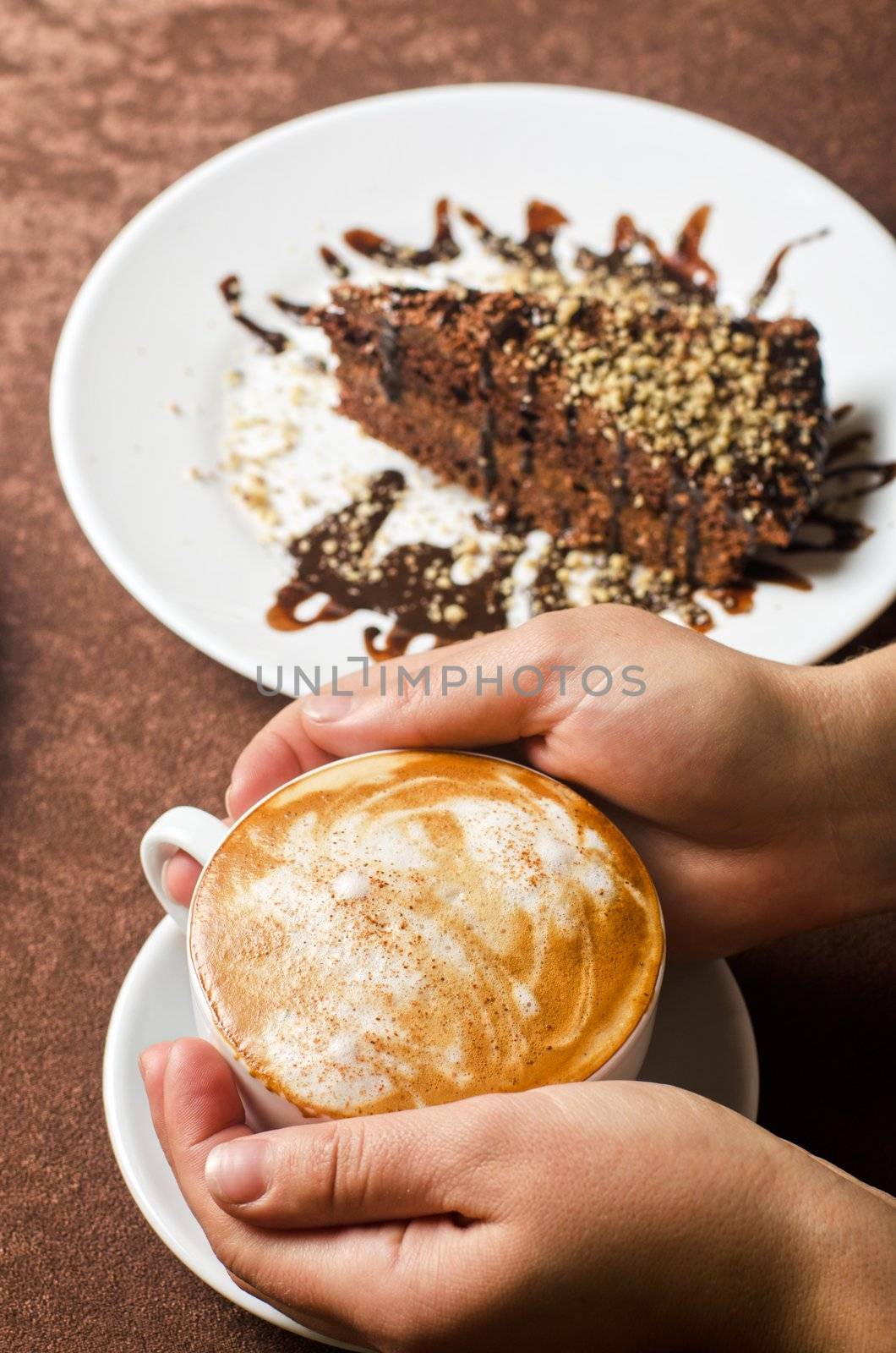 Closeup of female hands holding cup of Cappuccino