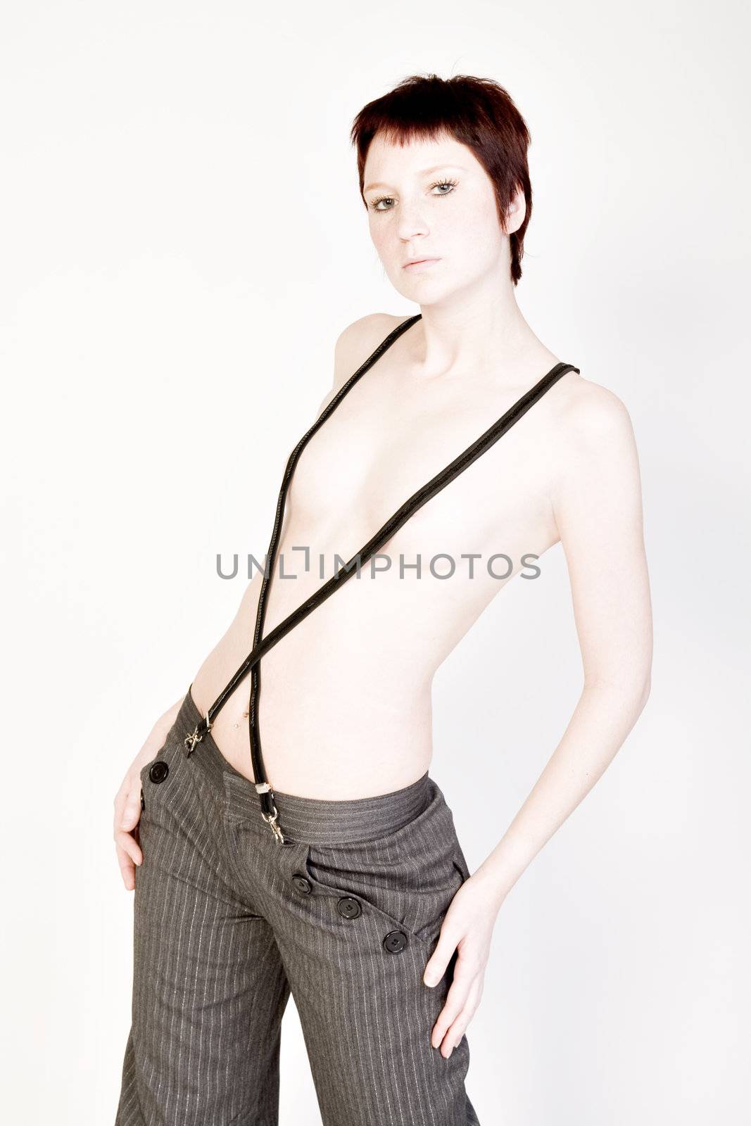 Studio portrait of a young woman with short hair and suspenders